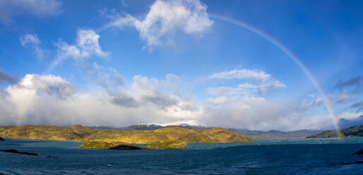 Chile, Ultima Esperanza Province, Scenic panorama of rainbow over shore of Lake Pehoe - LOMF01029