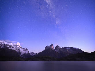 Chile, Ultima Esperanza Province, Milky Way galaxy on purple sky over Nordenskjld Lake and Cuernos del Paine at dusk - LOMF01035