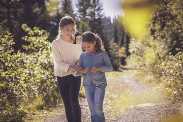 Two sisters walking on forest path - DHEF00120