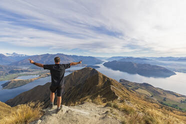 Hiker standing on viewpoint at Roys Peak, looking to Mount Aspiring, Lake Wanaka, South Island, New Zealand - FOF11832