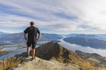 Hiker standing on viewpoint at Roys Peak, looking to Mount Aspiring, Lake Wanaka, South Island, New Zealand - FOF11833