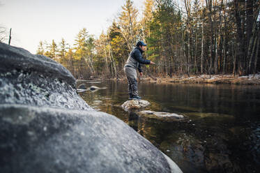 A man fly-fishes during a fall morning on a Maine river - CAVF74319
