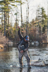 A man gets wrapped up in his flyline while fighting a fish in Maine - CAVF74337