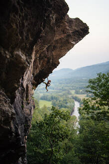 Mann klettert auf einer überhängenden Sportkletterroute in New Hampshire - CAVF74365