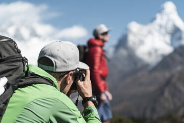 Man taking photos of friend on the Ama Dablam Expedition, Khumbu Nepal - CAVF74453