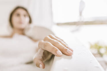 Hand of young woman relaxing in bathtub - SDAHF00096