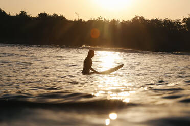 Female surfer at sunset, Bali, Indonesia - KNTF04286