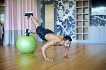 Ein Mann trainiert in einem Fitnessstudio. - CAVF74534
