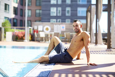 A fit man relaxes by the pool. - CAVF74536