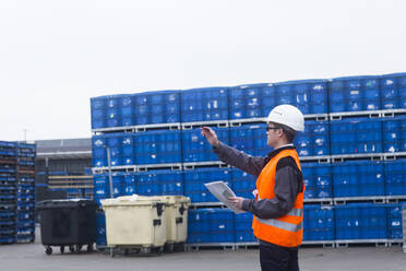 Arbeiter mit Helm in der Nähe von Containern - CAVF74575