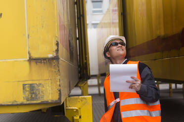 Arbeiter, der von außen auf einen Container blickt - CAVF74587