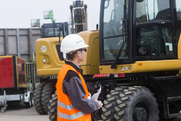 Worker outside in front of cranes - CAVF74590