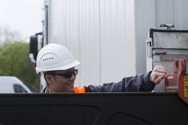 Worker outside opening a container - CAVF74596