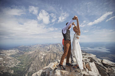 Braut und Bräutigam feiern nach der Eheschließung auf dem Gipfel eines Berges - CAVF74643