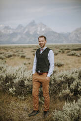 Porträt des Bräutigams mit Fliege vor einer Bergkulisse, Jackson Hole, WY - CAVF74679