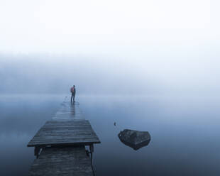 Mann auf Pier im See im Morgennebel - JOHF07685