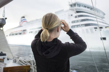 Woman looking at cruise ship - JOHF07845