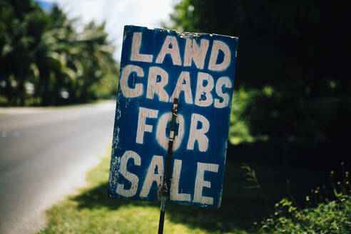 Handgeschriebenes Schild am Straßenrand, auf dem Landkrabben zum Verkauf angeboten werden. - MINF13308