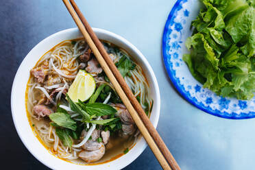 High angle close up of a bowl of bun bo hue, or beef noodle soup. - MINF13357