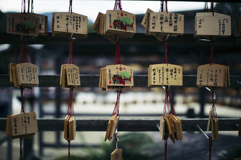 Nahaufnahme von Holztafeln mit auf Japanisch geschriebenen Botschaften an einem Schrein. - MINF13363