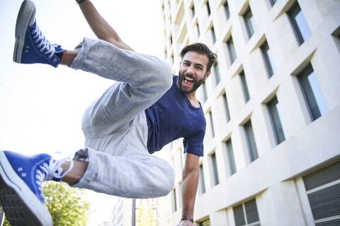 Portrait of happy man jumping in the city stock photo