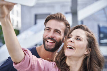 Ein glückliches Paar macht ein Selfie in der Stadt - PNEF02229