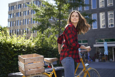 Brunette woman riding bicycle in the city - PNEF02257