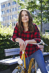 Porträt einer brünetten Frau mit Fahrrad in der Stadt - PNEF02258