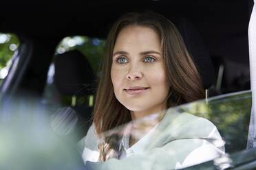 Portrait of confident woman sitting in car - PNEF02260