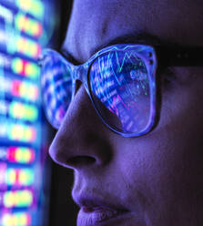 Weibliche Analystin betrachtet Finanzmarktdaten auf einem Bildschirm - ABRF00682