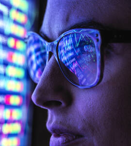 Weibliche Analystin betrachtet Finanzmarktdaten auf einem Bildschirm - ABRF00682