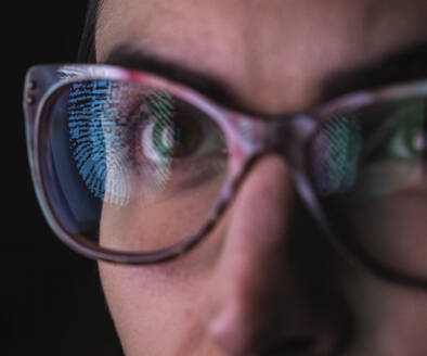 Frau mit Spiegelung eines Fingerabdrucks auf ihrer Brille als Symbol für Identität und Zugang - ABRF00683