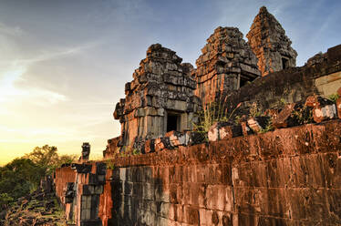 Ankor Wat, ein historischer Khmer-Tempel aus dem 12. Jahrhundert und UNESCO-Weltkulturerbe, mit Bögen, geschnitzten Steinblöcken und Stufen bei Sonnenuntergang. - MINF13393
