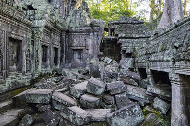Ankor Wat, ein historischer Khmer-Tempel aus dem 12. Jahrhundert und UNESCO-Weltkulturerbe: Bögen und geschnitzte Steinblöcke, umgestürztes Mauerwerk und vom Dschungel überwucherte Strukturen. - MINF13402