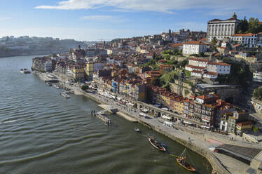 Blick von oben auf eine Küstenstadt mit einem an der Hafenmauer vertäuten Segelboot, Portugal. - MINF13414
