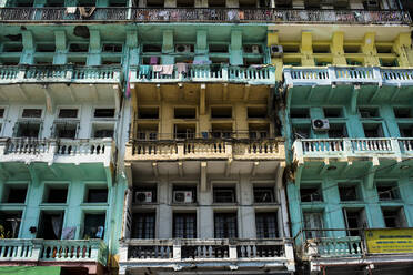 Low angle view of facade of an old apartment building, rows of balconies and windows. - MINF13483