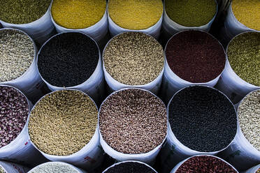 High angle close up of bags of fried beans and legumes for sale at a market. - MINF13511