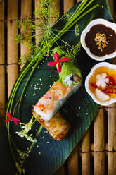 High angle close up of Vietnamese spring rolls served on a banana leaf. - MINF13530