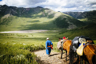 Reiseleiter und Reisende reiten mit Pferden in die Wälder der Ost-Taiga im Norden der Mongolei, um die abgelegenen, nomadischen Rentierzüchter zu besuchen, die nahe der sibirischen Grenze des Landes leben. - MINF13561