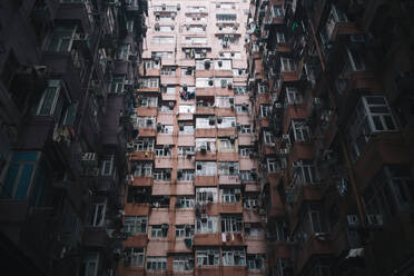 Low angle view of facade of towering residential complex with windows and balconies. - MINF13567