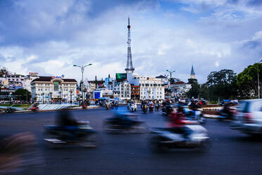Urban scene with blurred motion of passing traffic and motorbikes on wide street. - MINF13583