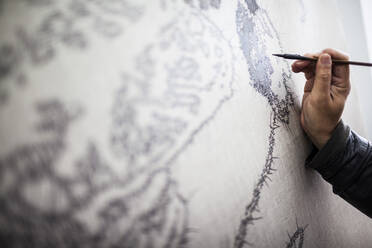 Close up of artist at work on a new painting in a studio. - MINF13589