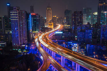 Erhöhte Ansicht einer gestapelten Straßenkreuzung und der Skyline von Shanghai in der Abenddämmerung, Shanghai, China - MINF13593