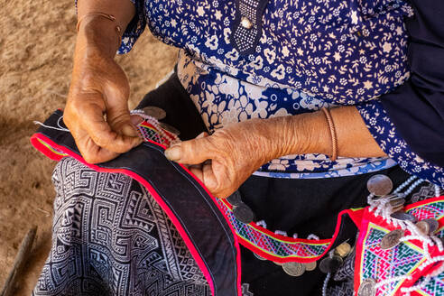 Frau sitzt und näht, Herstellung traditioneller Kleidungsstücke, Vang Vieng, Laos - MINF13607