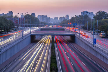 Traffic trail lights on major road near Beijing Zoo at dusk, Beijing, People's Republic of China, Asia - RHPLF13727