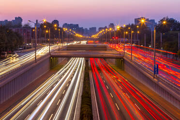 Traffic trail lights on major road near Beijing Zoo at dusk, Beijing, People's Republic of China, Asia - RHPLF13732