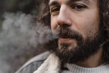 Porträt eines jungen Mannes, der im Freien raucht - AFVF05274