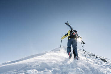 Mann im Gegenlicht auf Skitour, Graubünden, Schweiz - HBIF00019