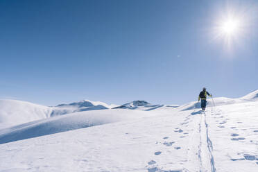 Man in backlight on ski tour, Grisons, Switzerland - HBIF00021