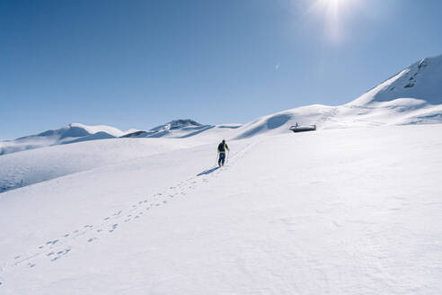 Mann im Gegenlicht auf Skitour, Graubünden, Schweiz - HBIF00022
